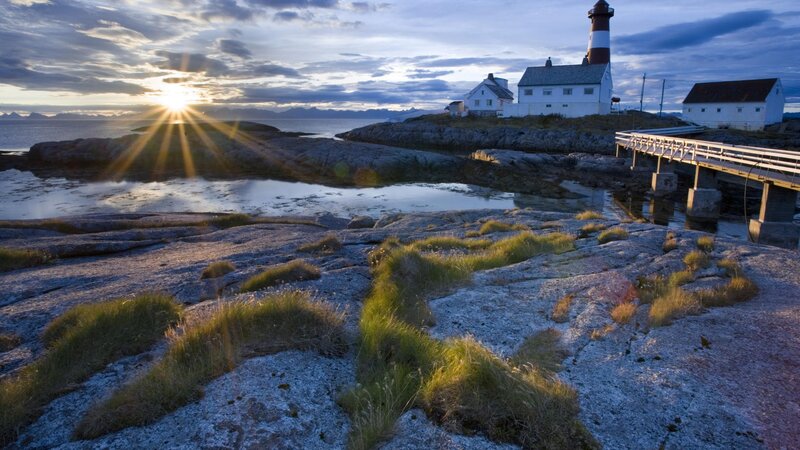 lighthouse at sunset on rocky coast
