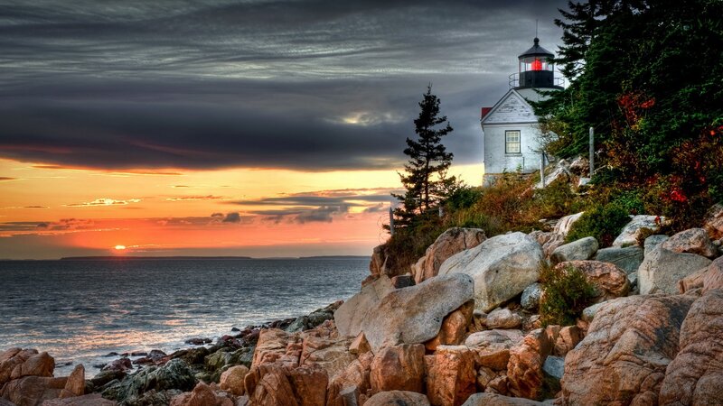 lighthouse at sunset on rocky coast