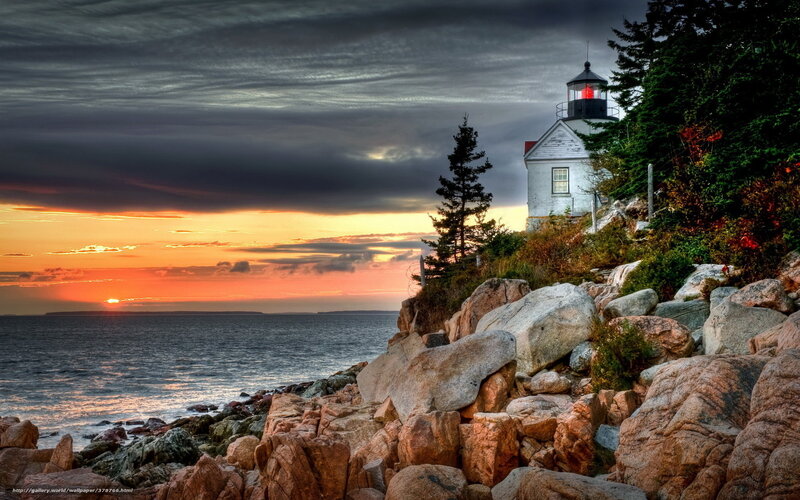 Lighthouse at sunset on rocky coast