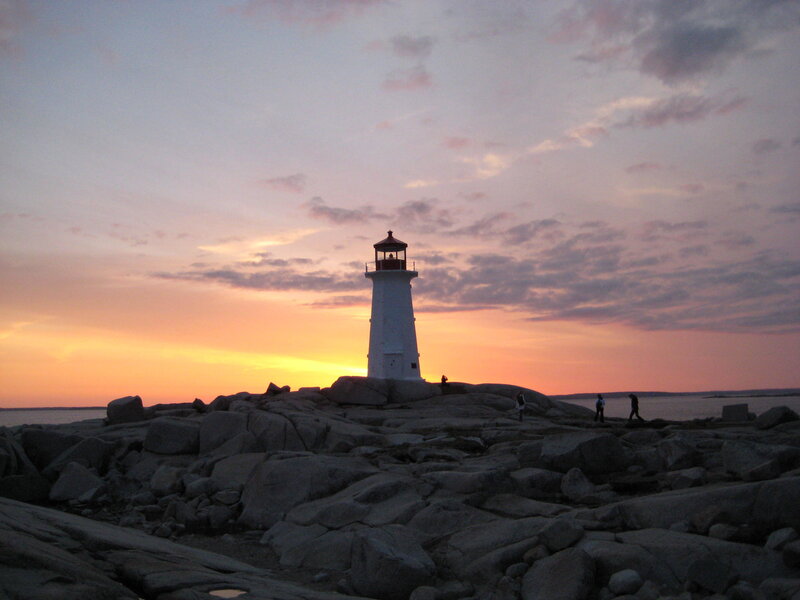 Lighthouse at sunset on rocky shore