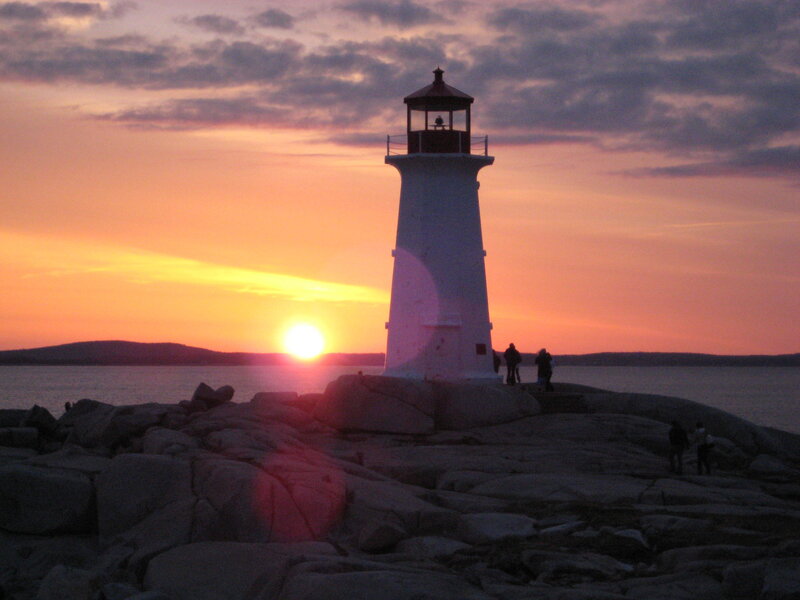 Lighthouse at sunset on rocky shore