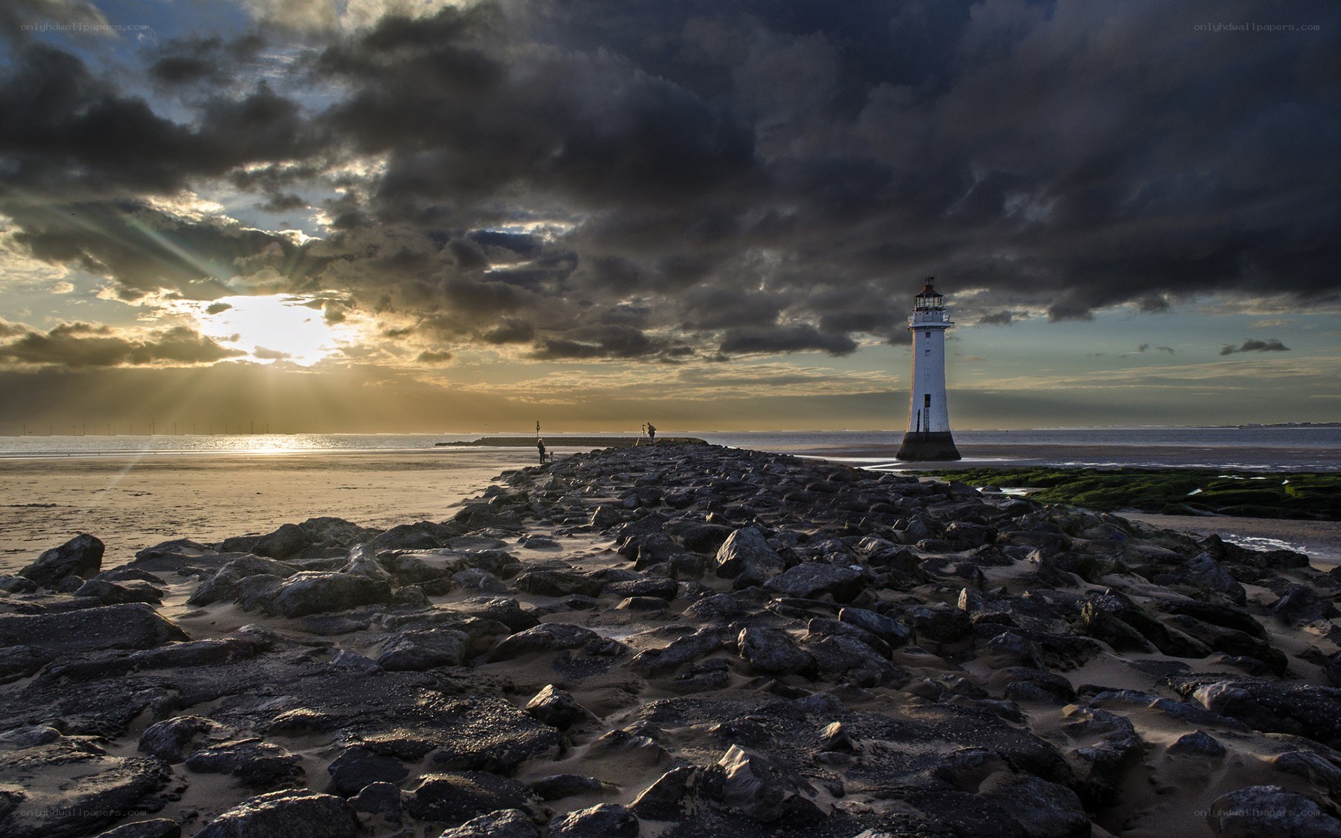 Lighthouse at sunset on rocky shore