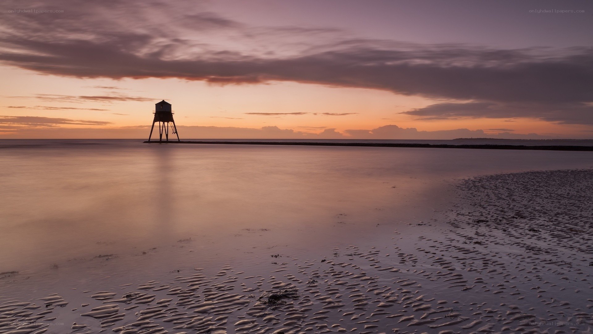 Lighthouse at sunset on the beach