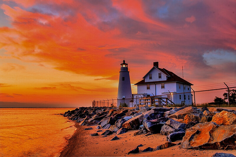 Lighthouse at Sunset — Orange, Dramatic, Photograph, Ocean, Rocks, Fence