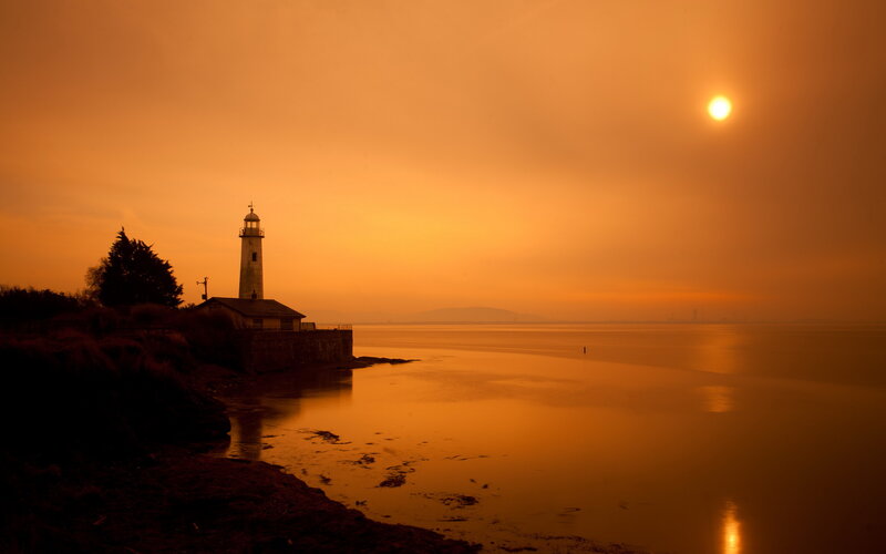 Lighthouse at Sunset — Orange, Serene, Photograph, Sun, Sea, Trees