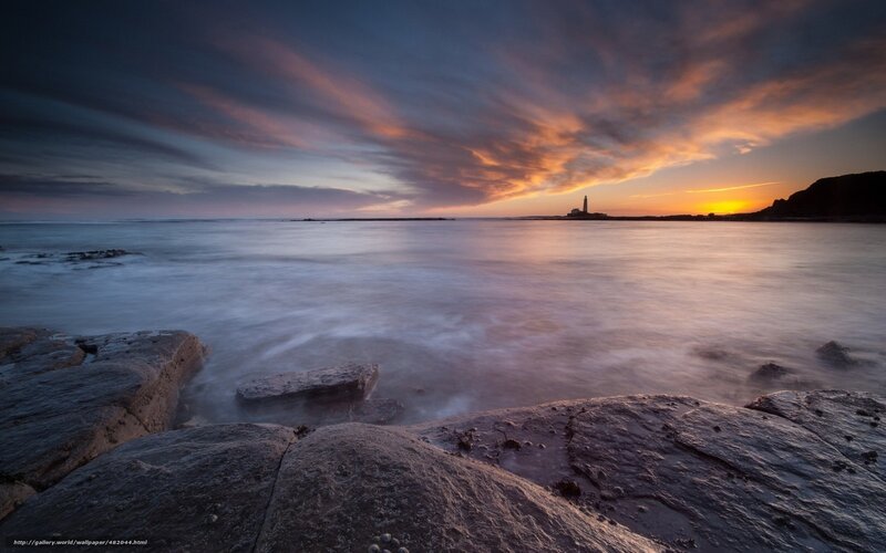Lighthouse at sunset over sea