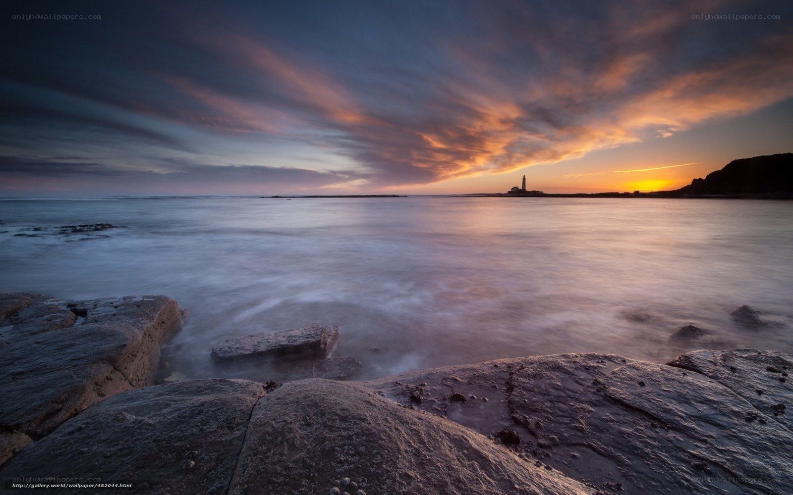 Lighthouse at sunset over sea
