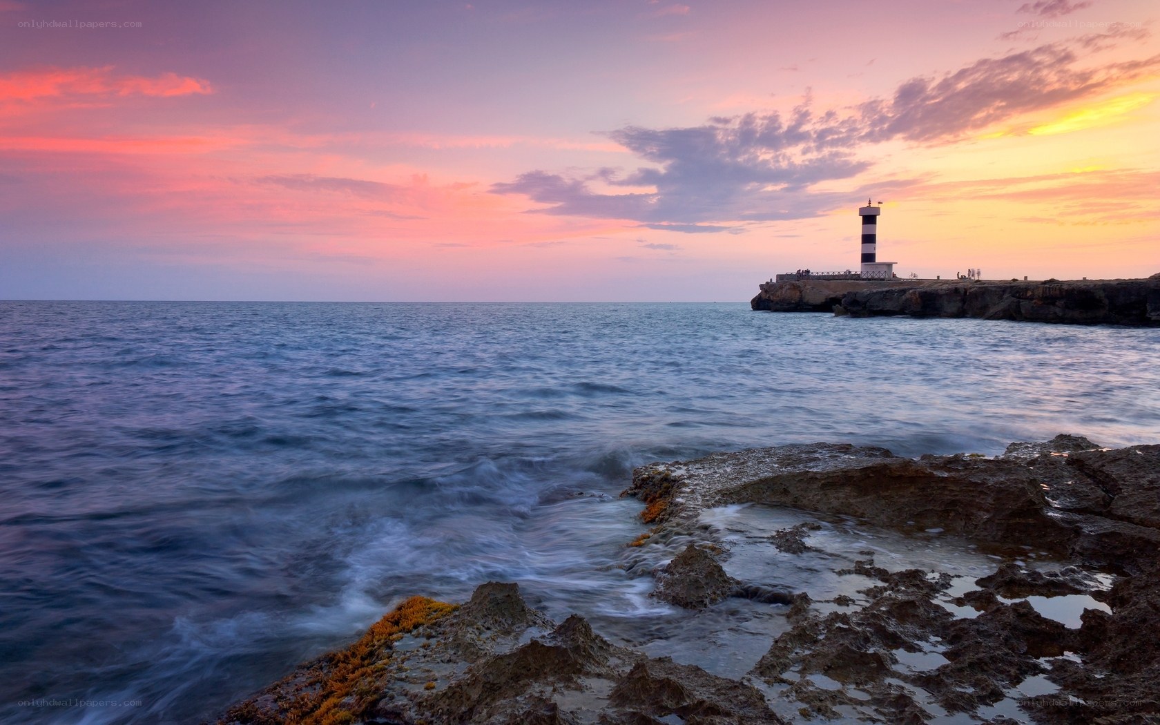 Lighthouse at sunset over sea