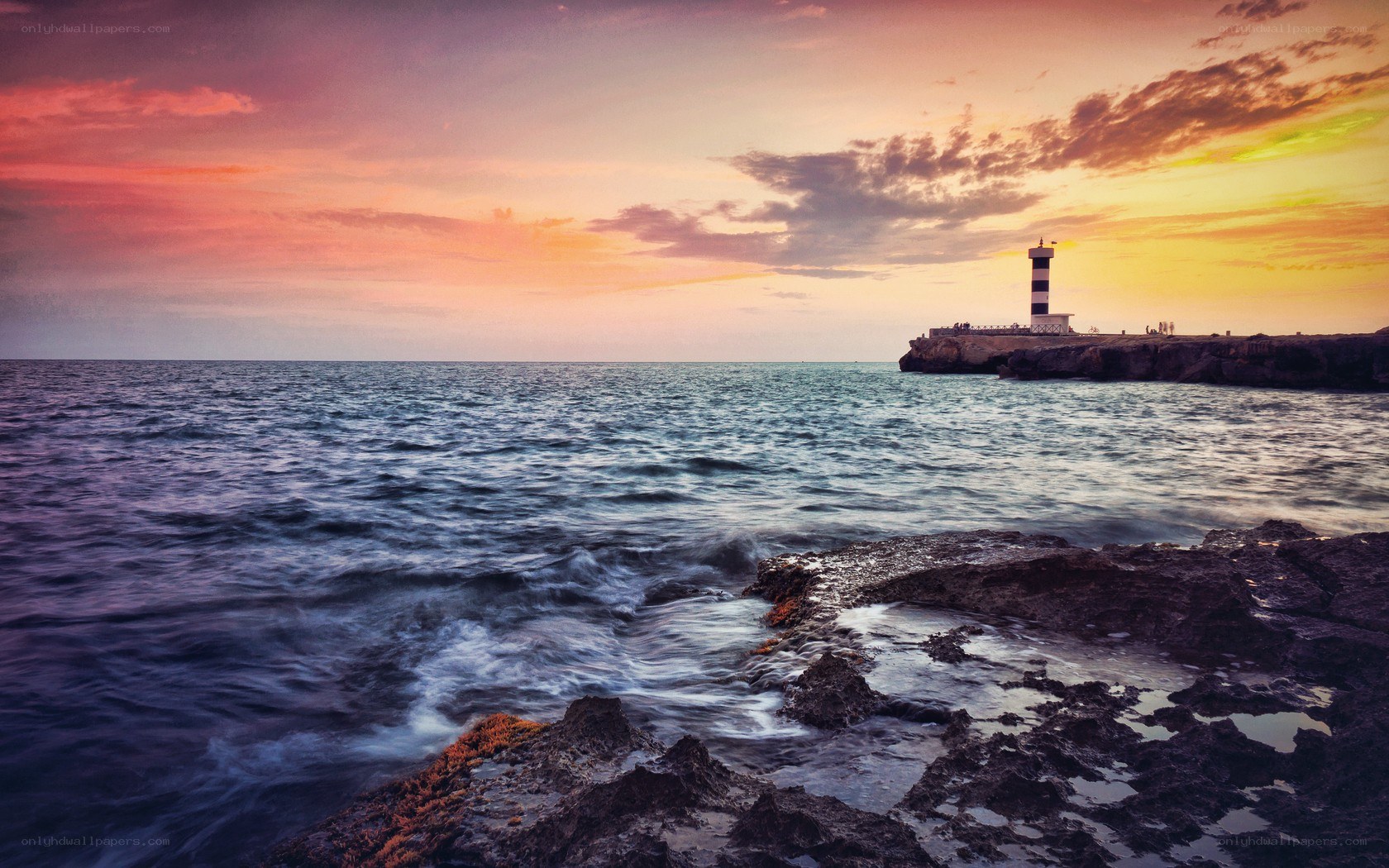 Lighthouse at sunset over the sea