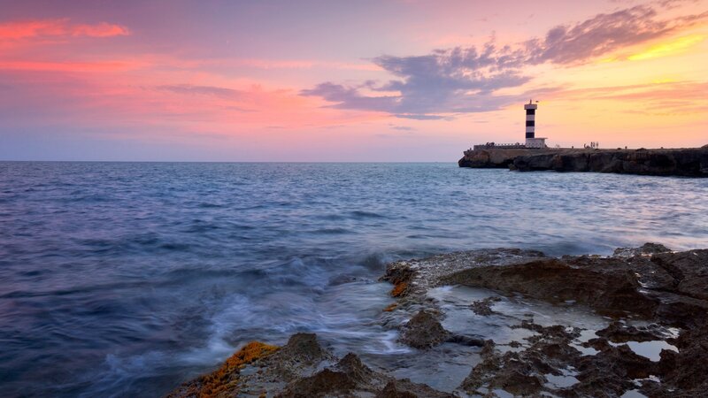 Lighthouse at sunset over the sea