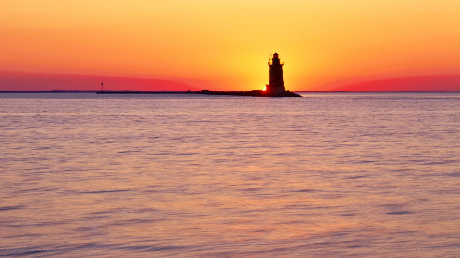 lighthouse at sunset over water