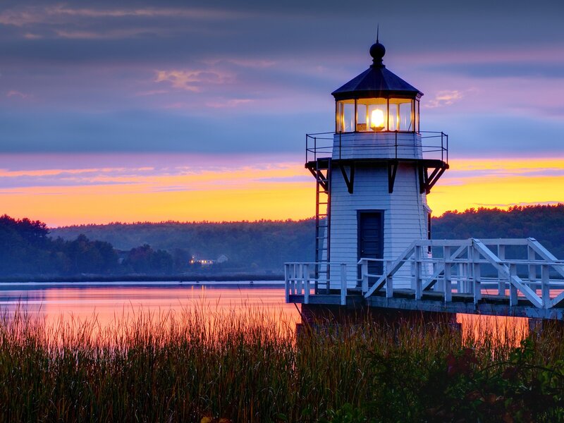 Lighthouse at sunset over water