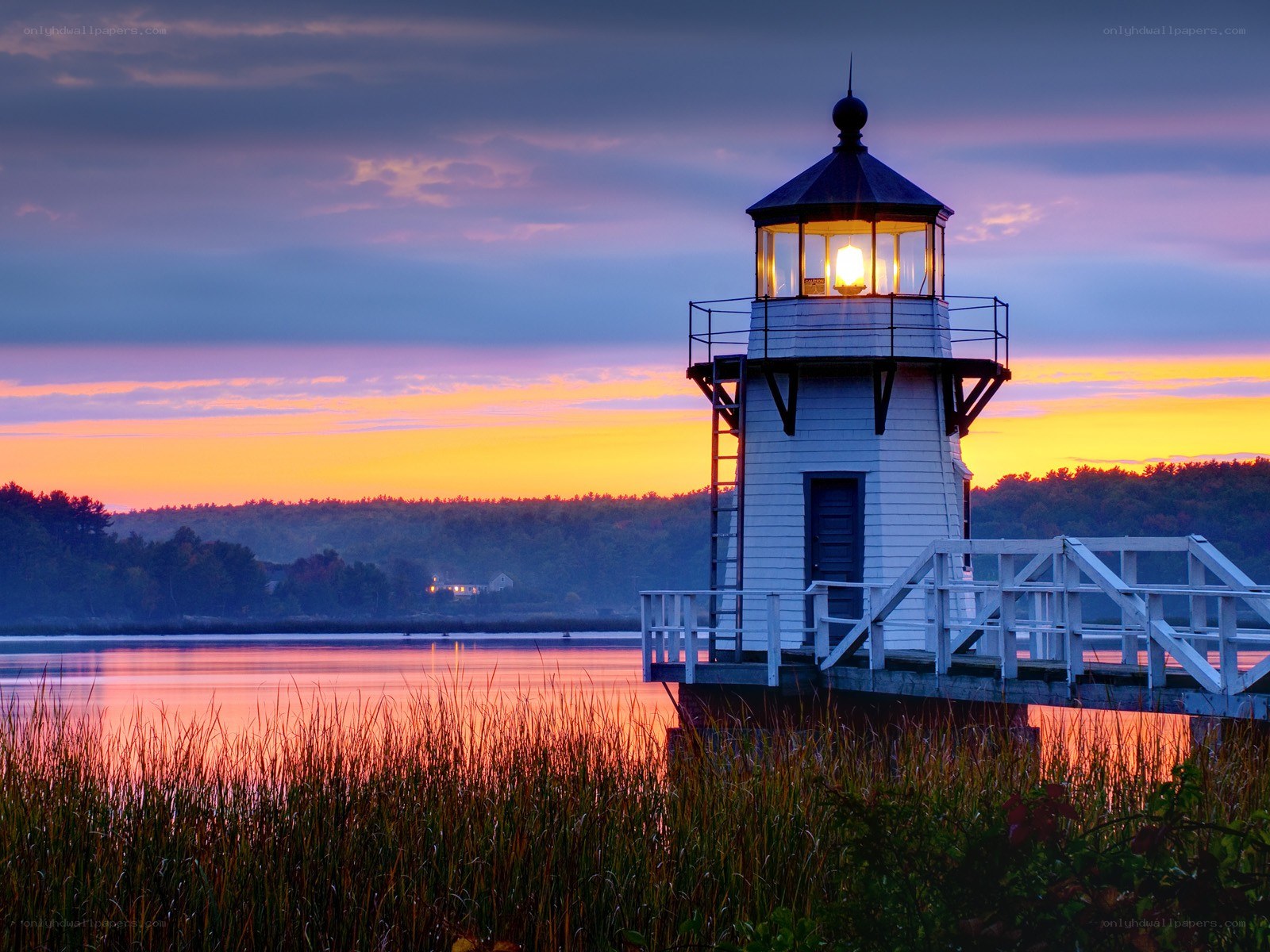 Lighthouse at sunset over water