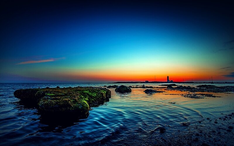 lighthouse at sunset over water