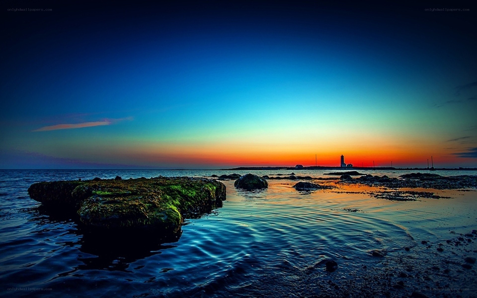 lighthouse at sunset over water