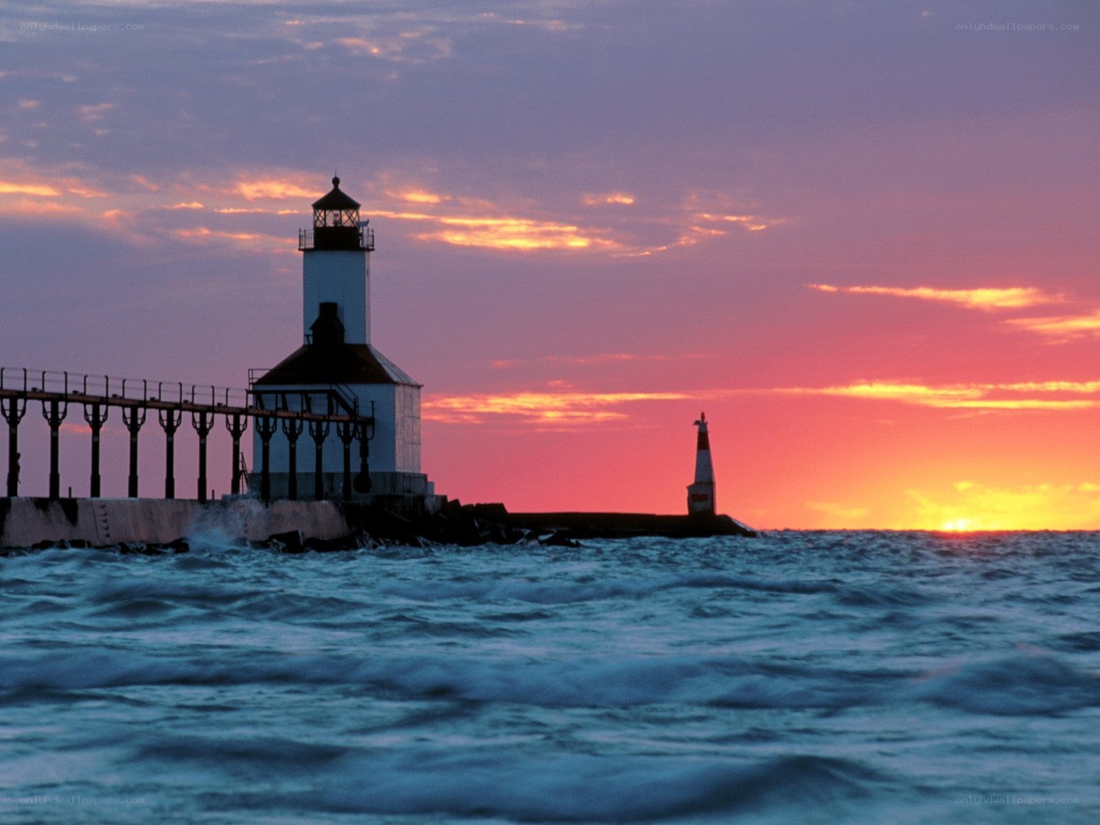 lighthouse at sunset over water