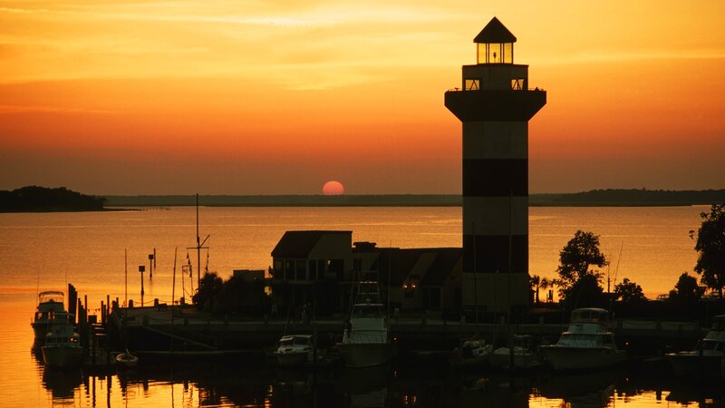 lighthouse at sunset over water