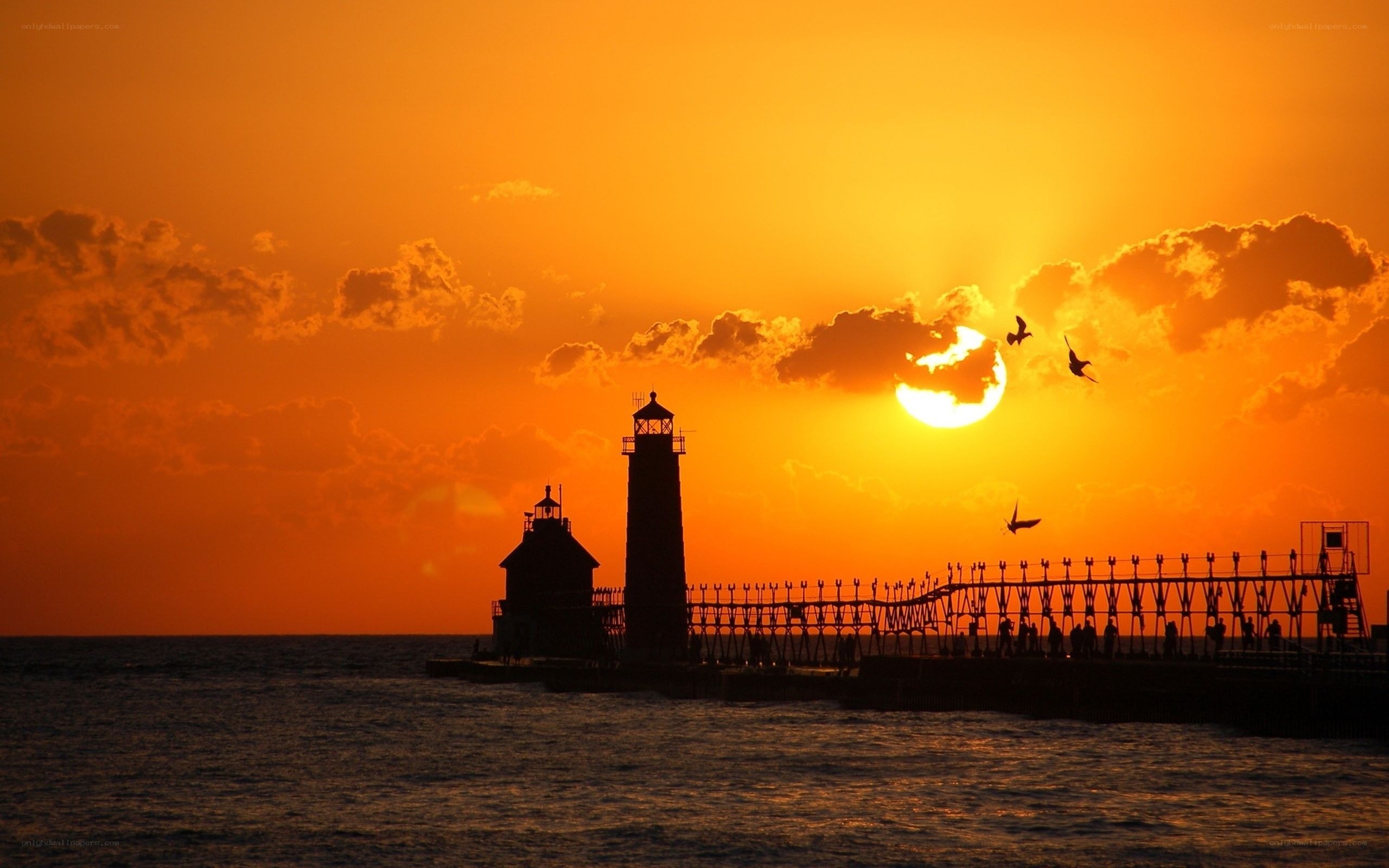 Lighthouse at sunset with birds