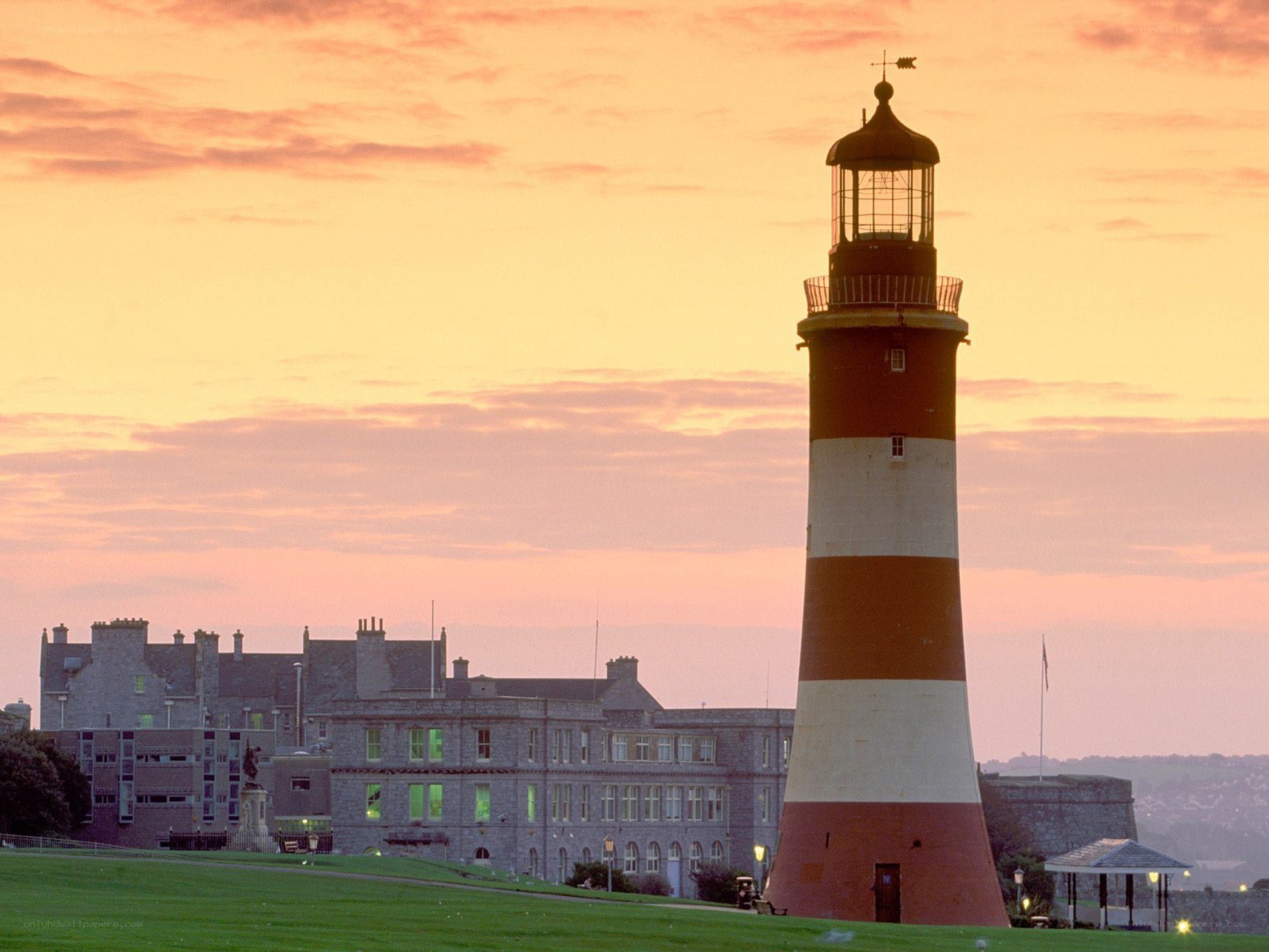 lighthouse at sunset with buildings