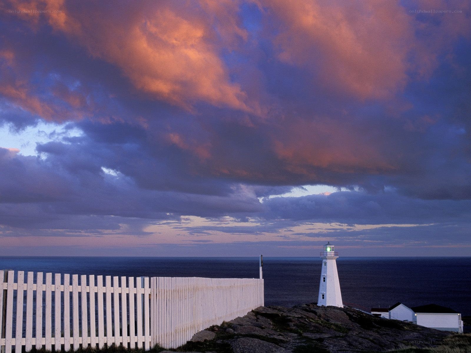 Lighthouse at sunset with cloudy sky
