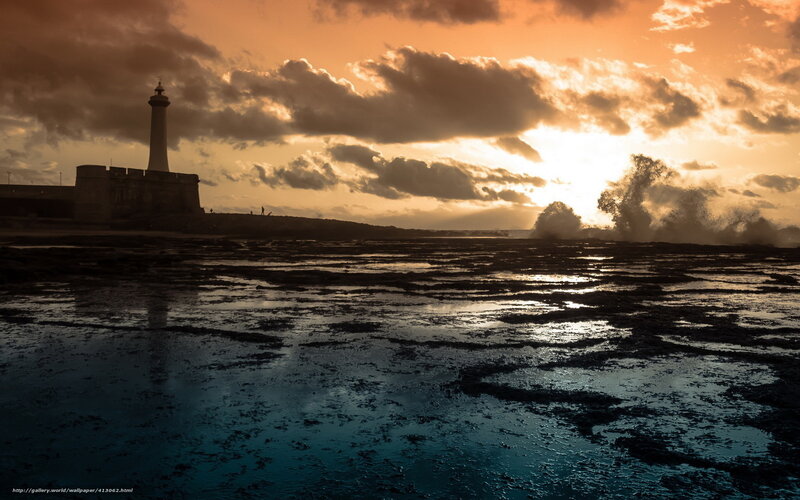 Lighthouse at sunset with crashing waves