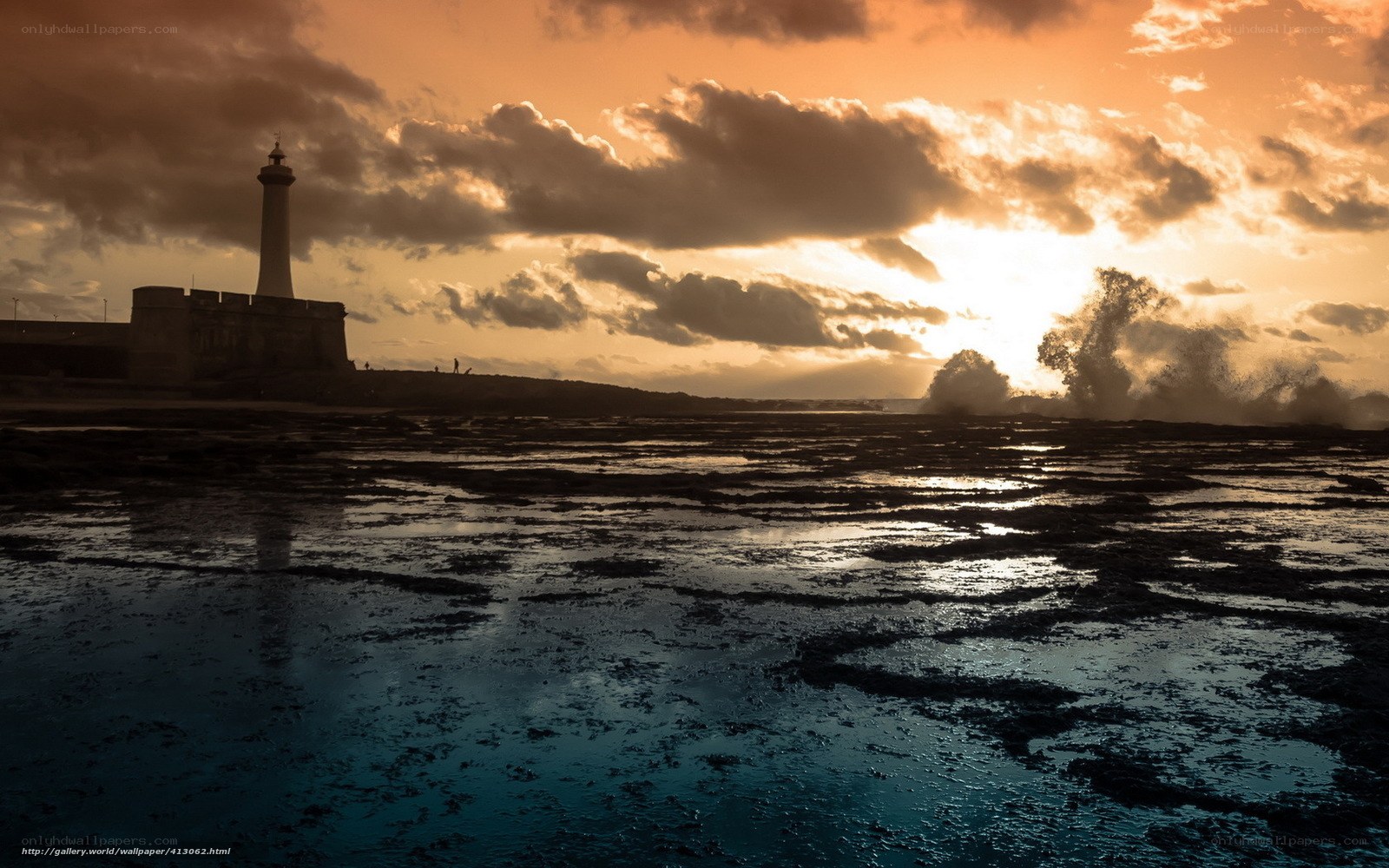 Lighthouse at sunset with crashing waves
