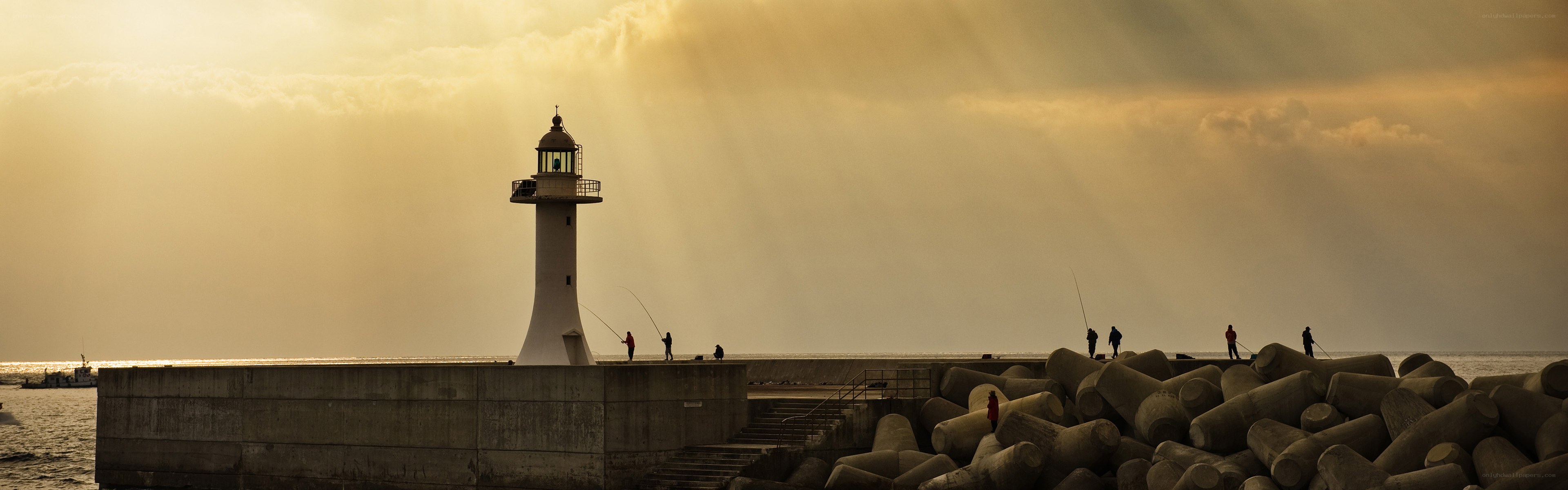 Lighthouse at sunset with fishermen