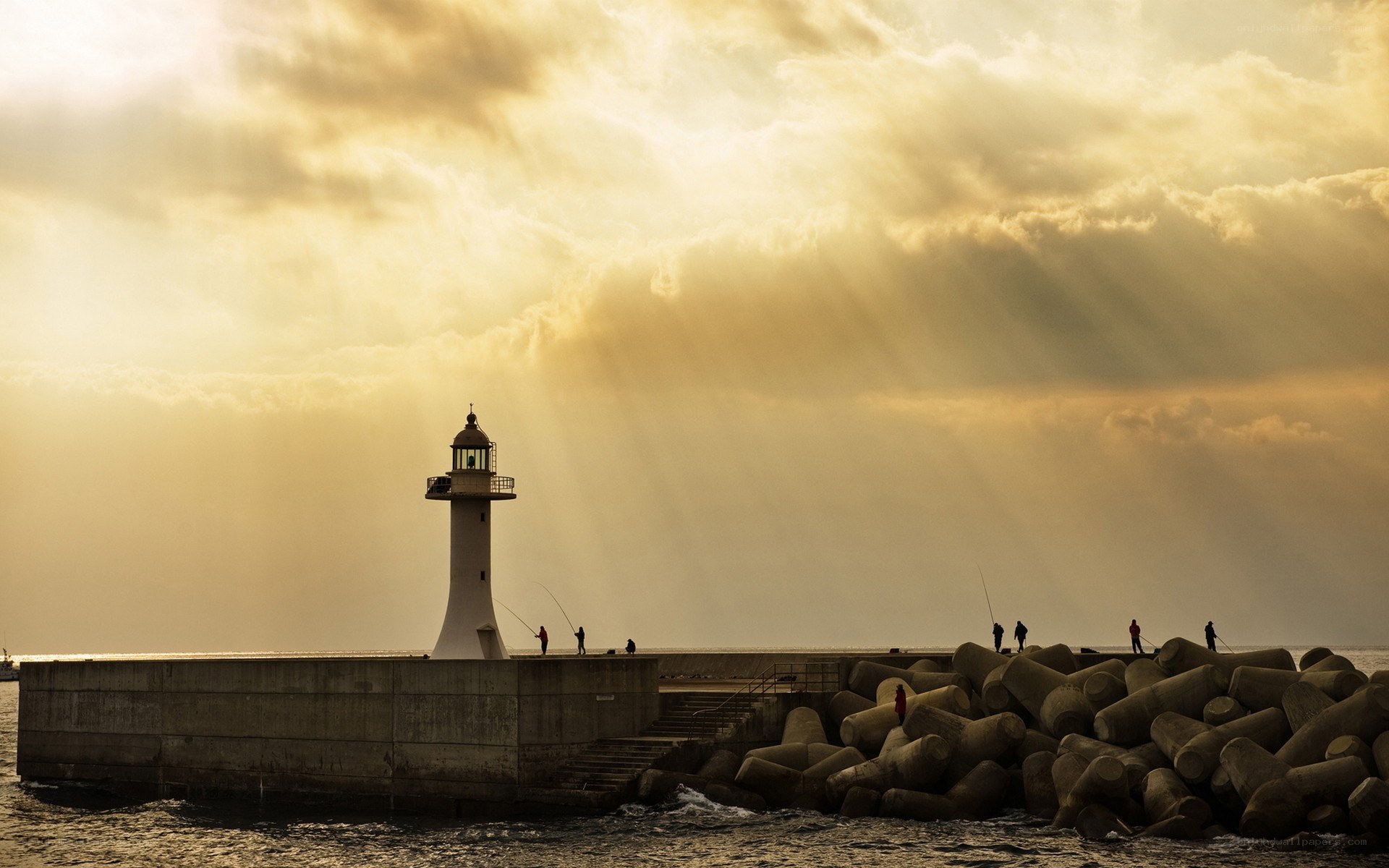 Lighthouse at sunset with fishermen
