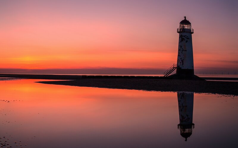 Lighthouse at sunset with reflection