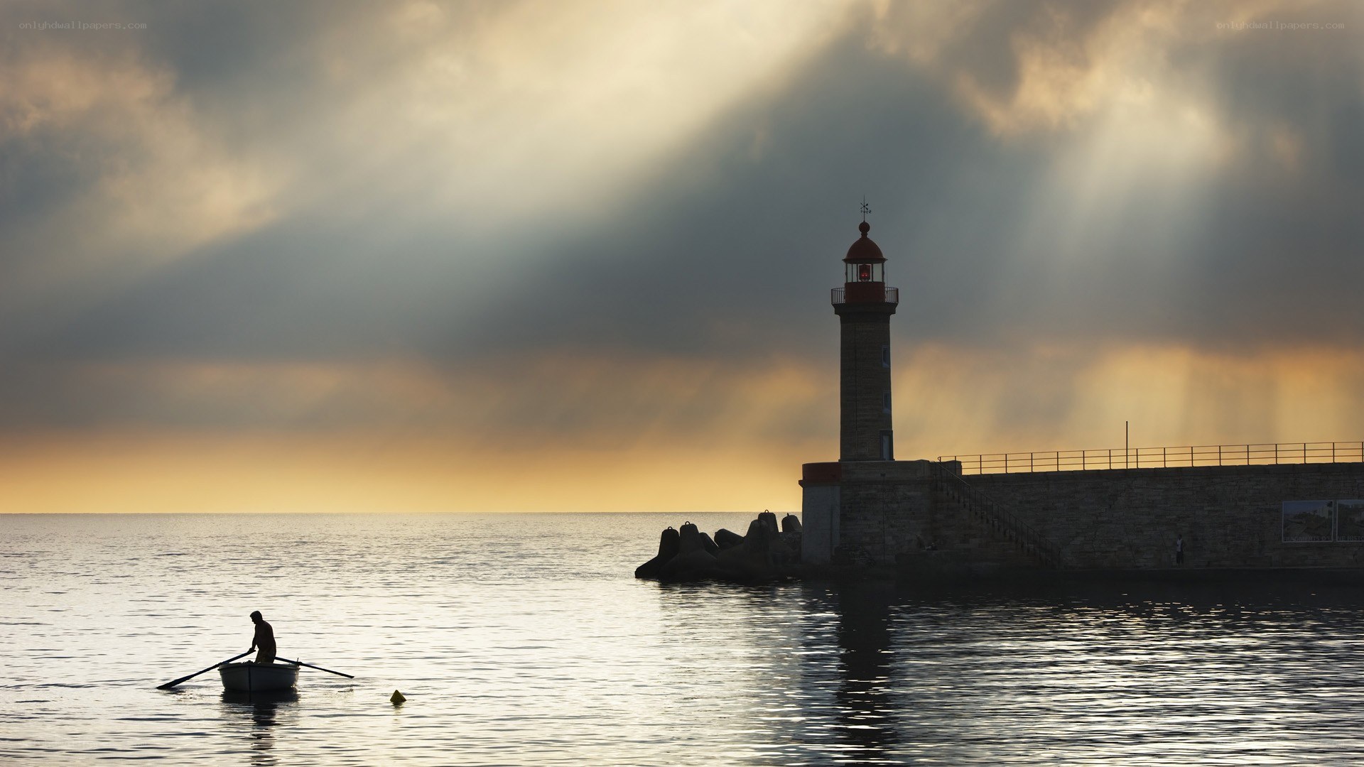 Lighthouse at sunset with rower