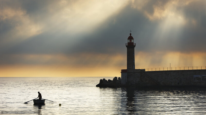 Lighthouse at sunset with rower