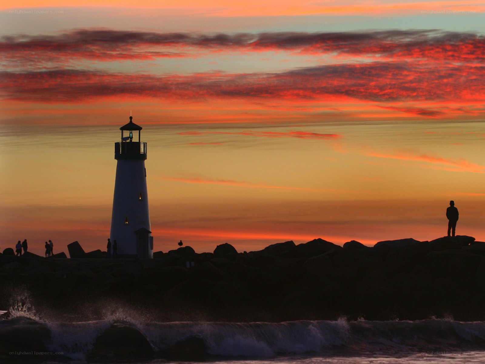 Lighthouse at sunset with silhouettes
