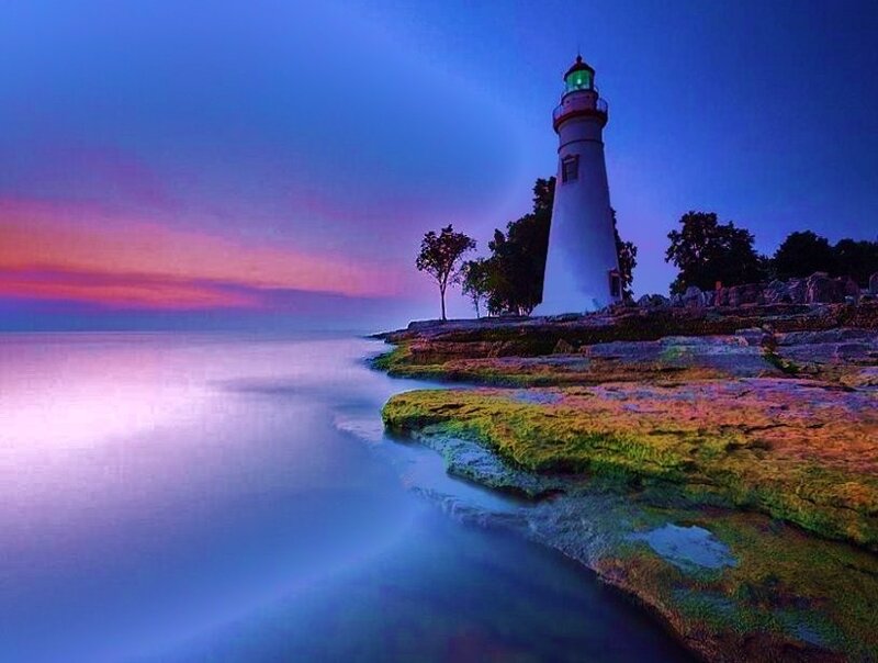 Lighthouse at twilight on a rocky shore