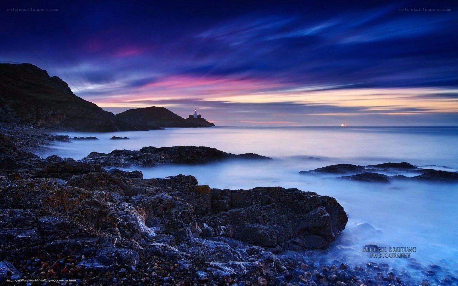 Lighthouse at twilight on rocky coast
