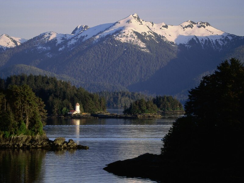 lighthouse by snowy mountains