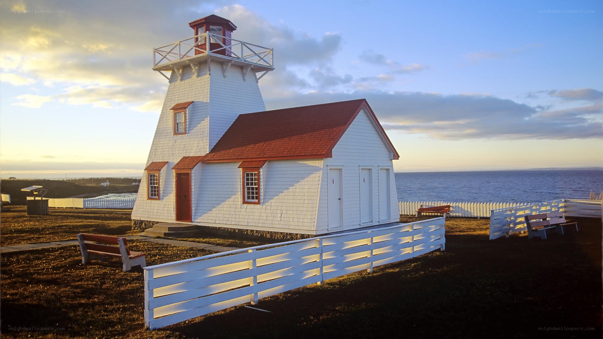 Lighthouse by the sea at sunset