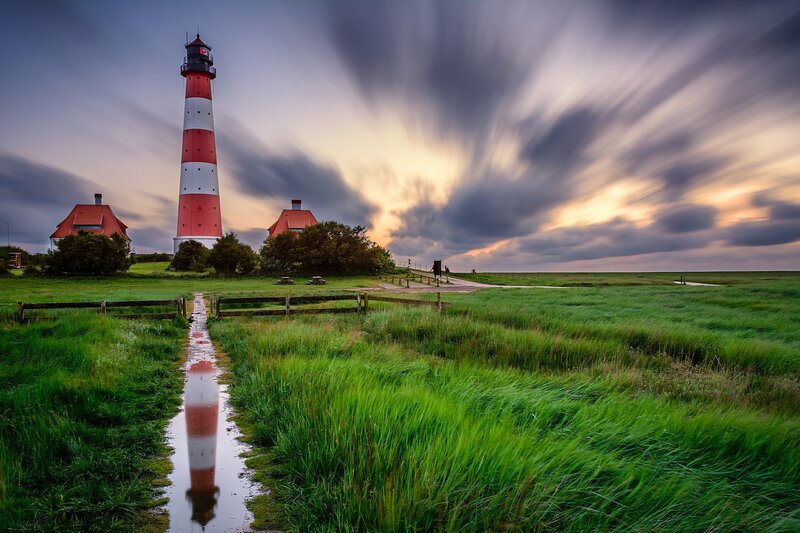Lighthouse in Grassy Field