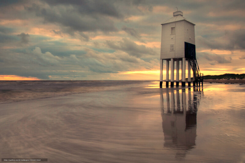 Lighthouse on a beach at sunset