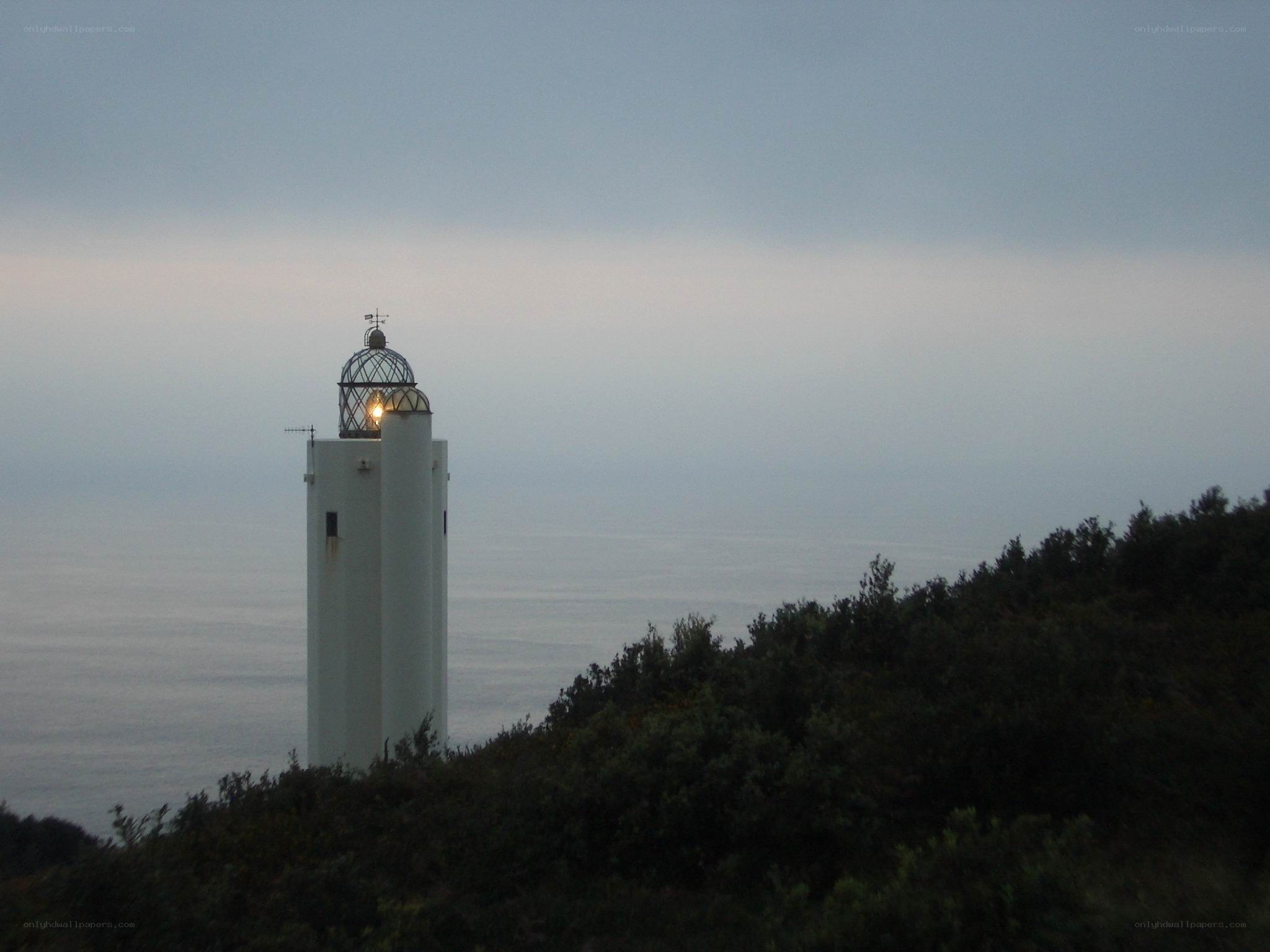 lighthouse on a cliff at dusk