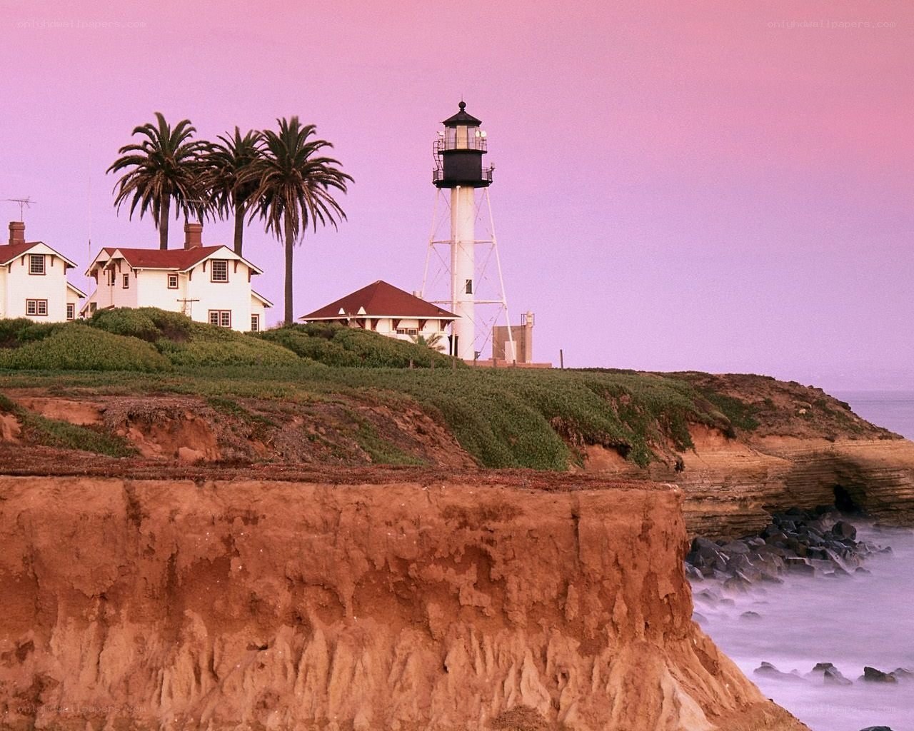 Lighthouse on a cliff at sunset