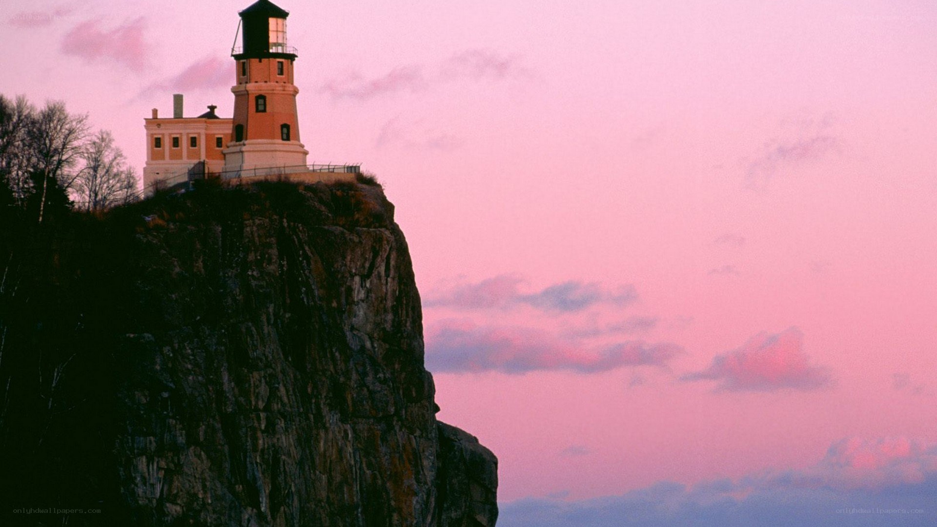 lighthouse on a cliff at sunset