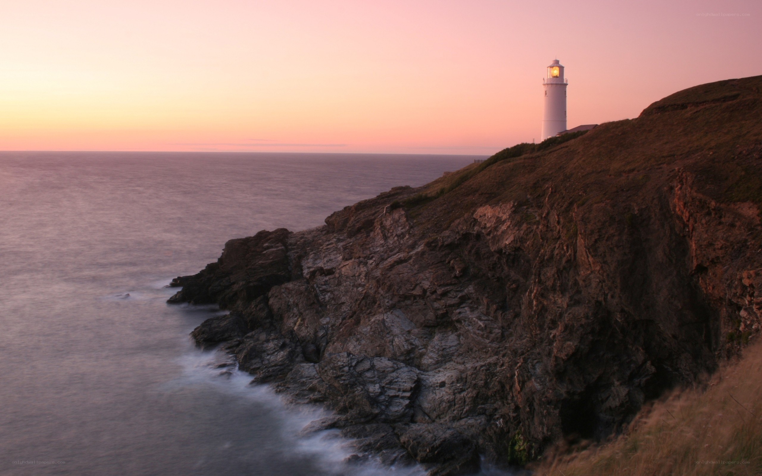 Lighthouse on a cliff at sunset