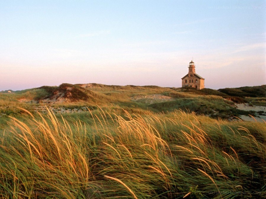 Lighthouse on a dune at sunset