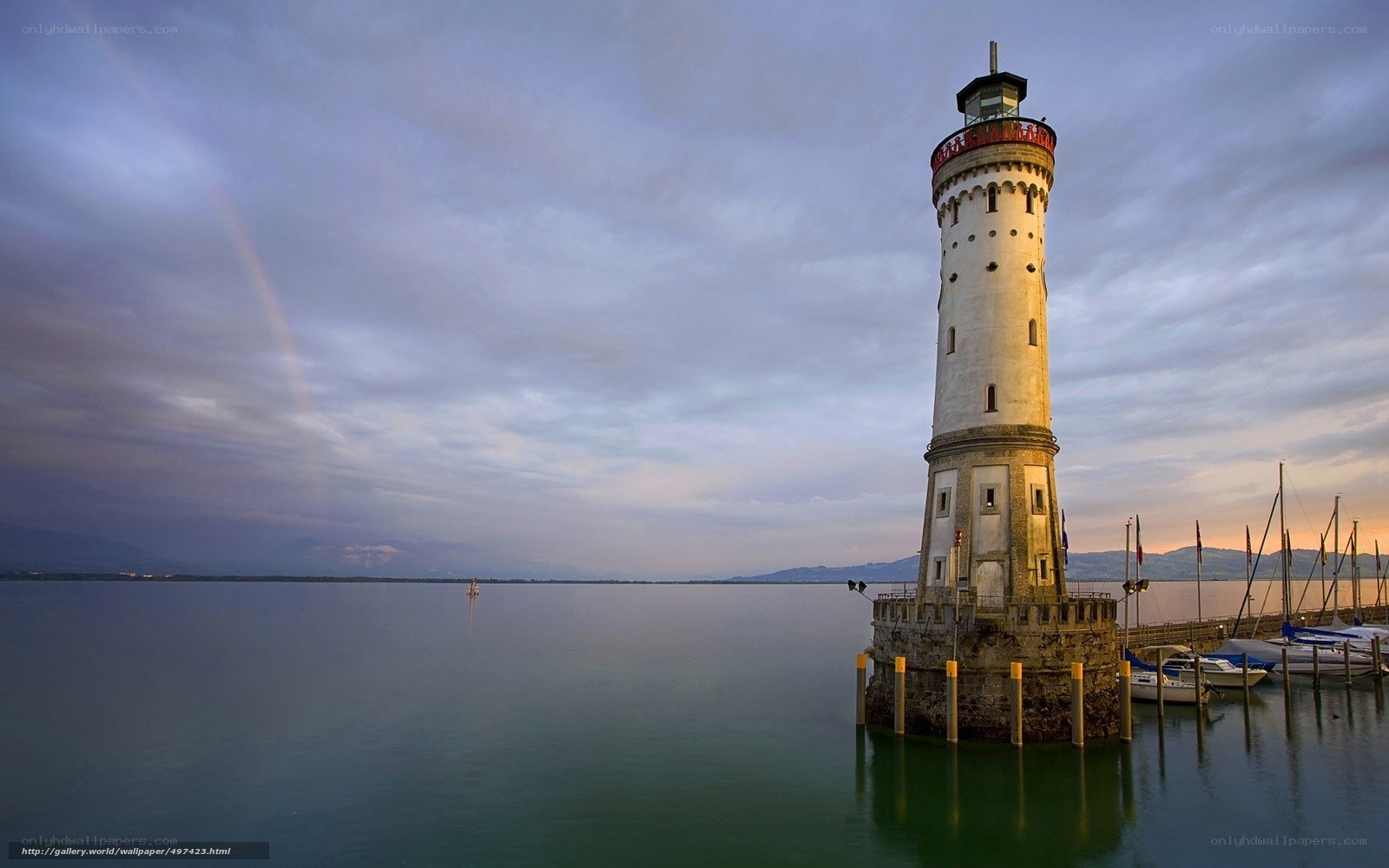 lighthouse on a lake at sunset