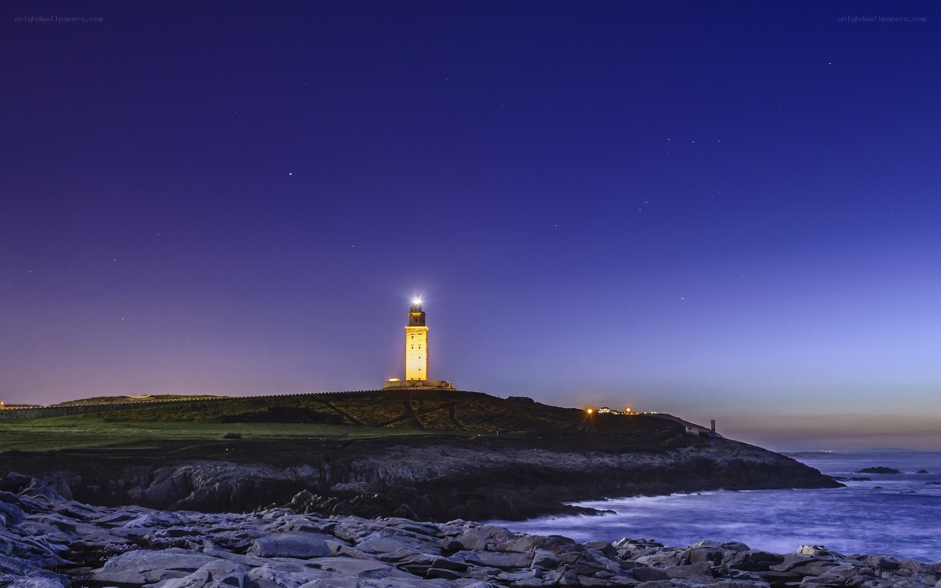Lighthouse on a rocky coast at night