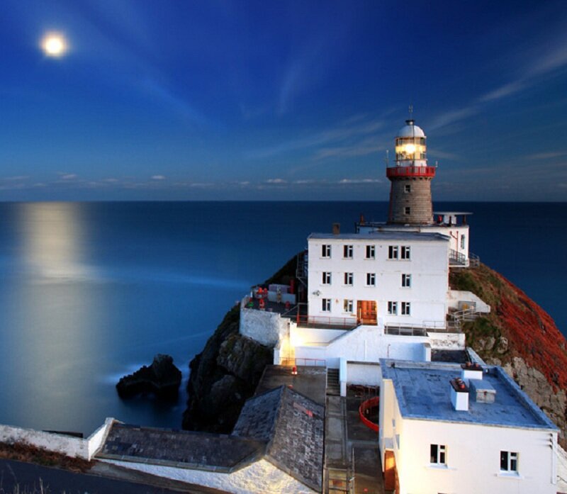 Lighthouse on Cliff — Blue, Serene, Night, Photograph, Moon