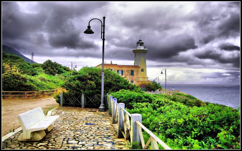 Lighthouse on Cliff — Green, Dramatic, Afternoon, Photograph, Bench