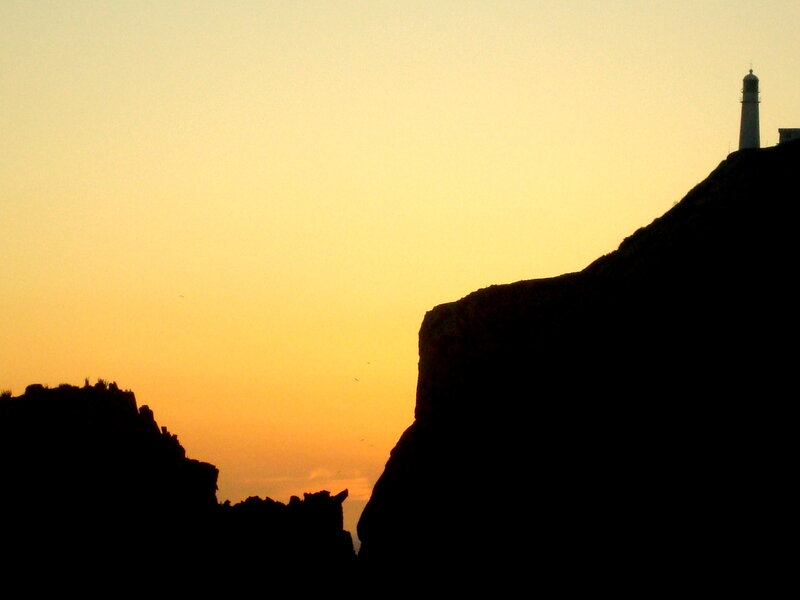 Lighthouse on Cliff — Orange, Serene, Sunset, Photograph, Sky