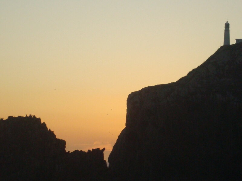 Lighthouse on Cliff — Orange, Serene, Sunset, Photograph