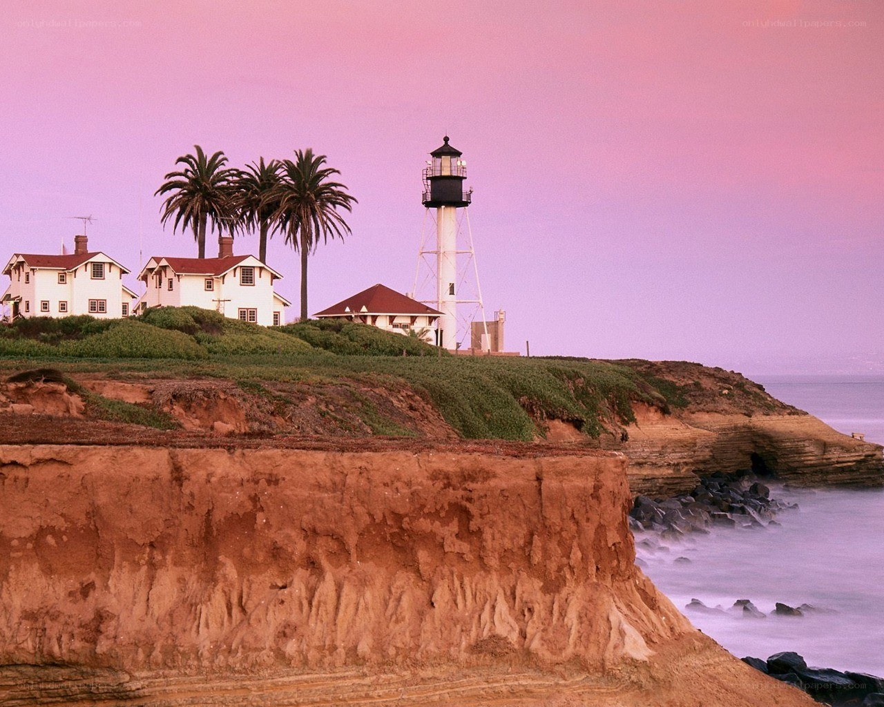 lighthouse on coastal cliff at sunset
